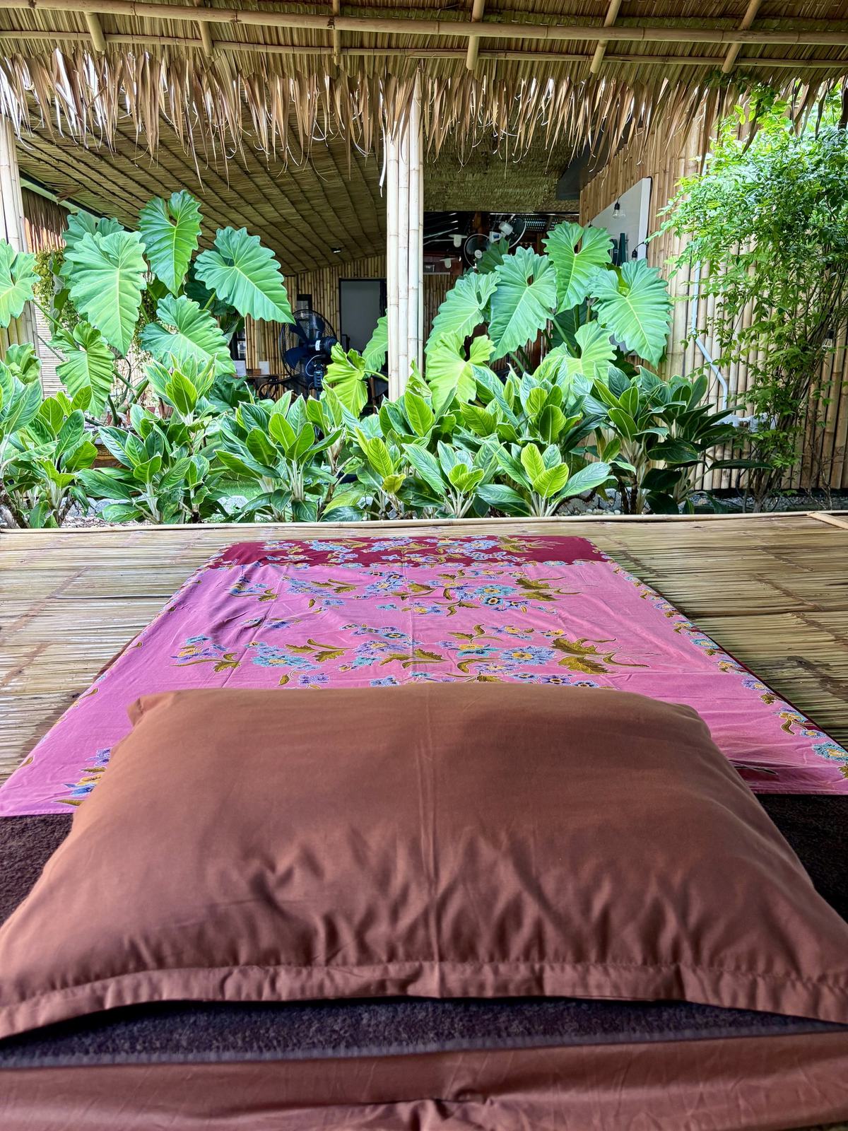 A massage mat with fresh linens in the open-air sala at Vihara, looking out to the garden