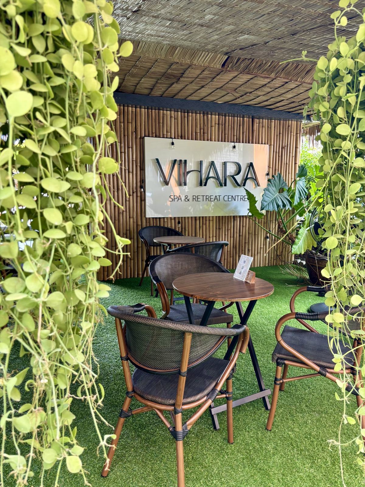Café seating beneath the Vihara Spa and Retreat Centre sign